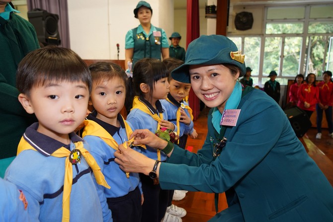 香港女童軍總會元朗助理區總監朱偉旗女士為「快樂小蜜蜂」監誓及帶上黃色小領巾