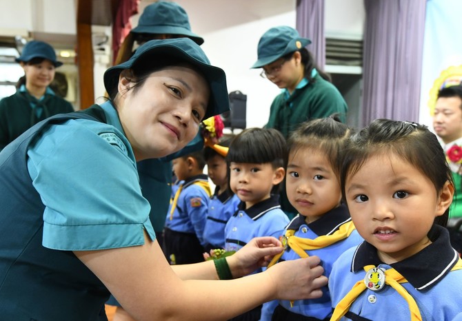 香港女童軍總會北區助理區總監馮桂芳女士為「快樂小蜜蜂」監誓及帶上黃色小領巾