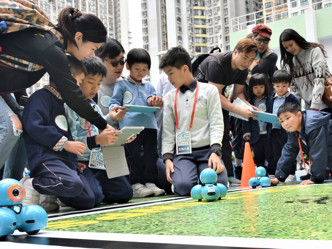 仁濟學生指導幼兒如何控制互動機械人進行遊戲