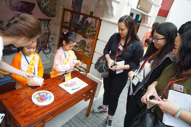 当地幼儿化身广彩陶瓷店的店员，与仁济幼师进行互动游戏