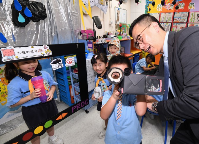 杨润雄局长与扮演报导天气记者及摄影师的幼儿打成一片，乐也融融