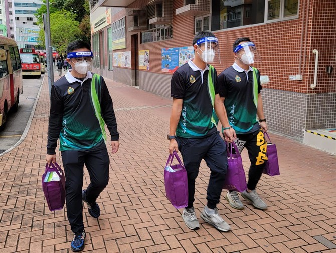 香港海關義工隊成員參與「仁濟•愛海顯關懷送暖行動」，為荃灣劏房戶送上支援抗疫包