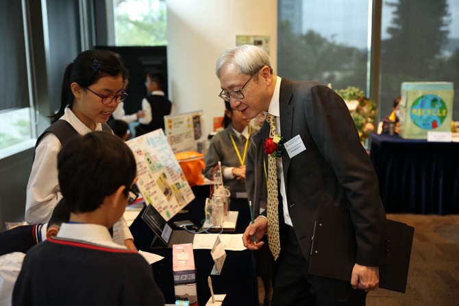 學生向總評評審團主席香港城市大學李兆基教授(電子學習)葉豪盛教授MH介紹發明作品的設計慨念及用途